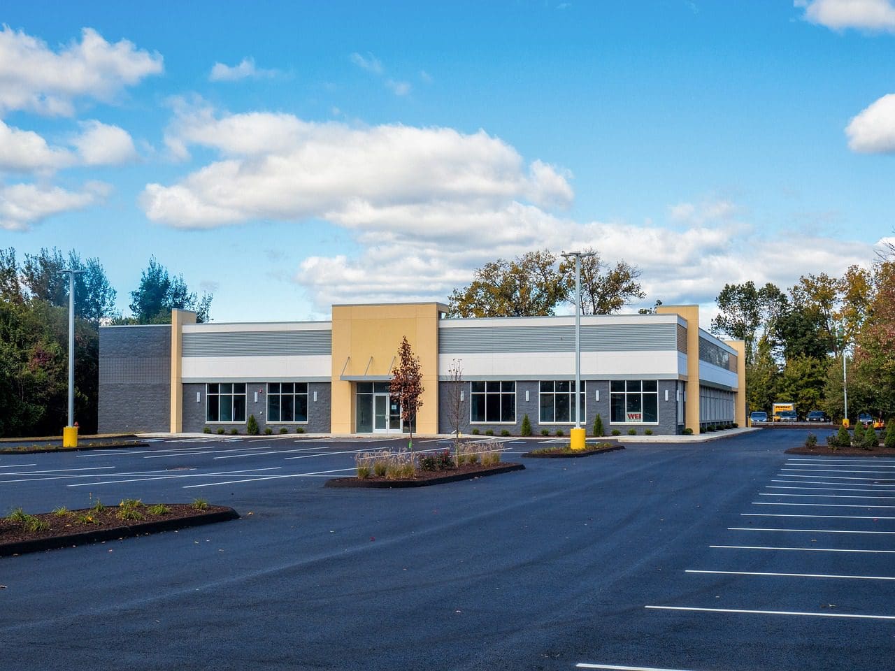 A large empty parking lot with a building in the background.