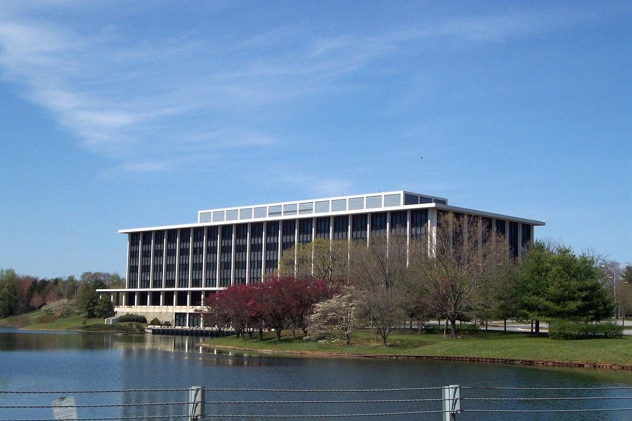 A building with trees and water in front of it