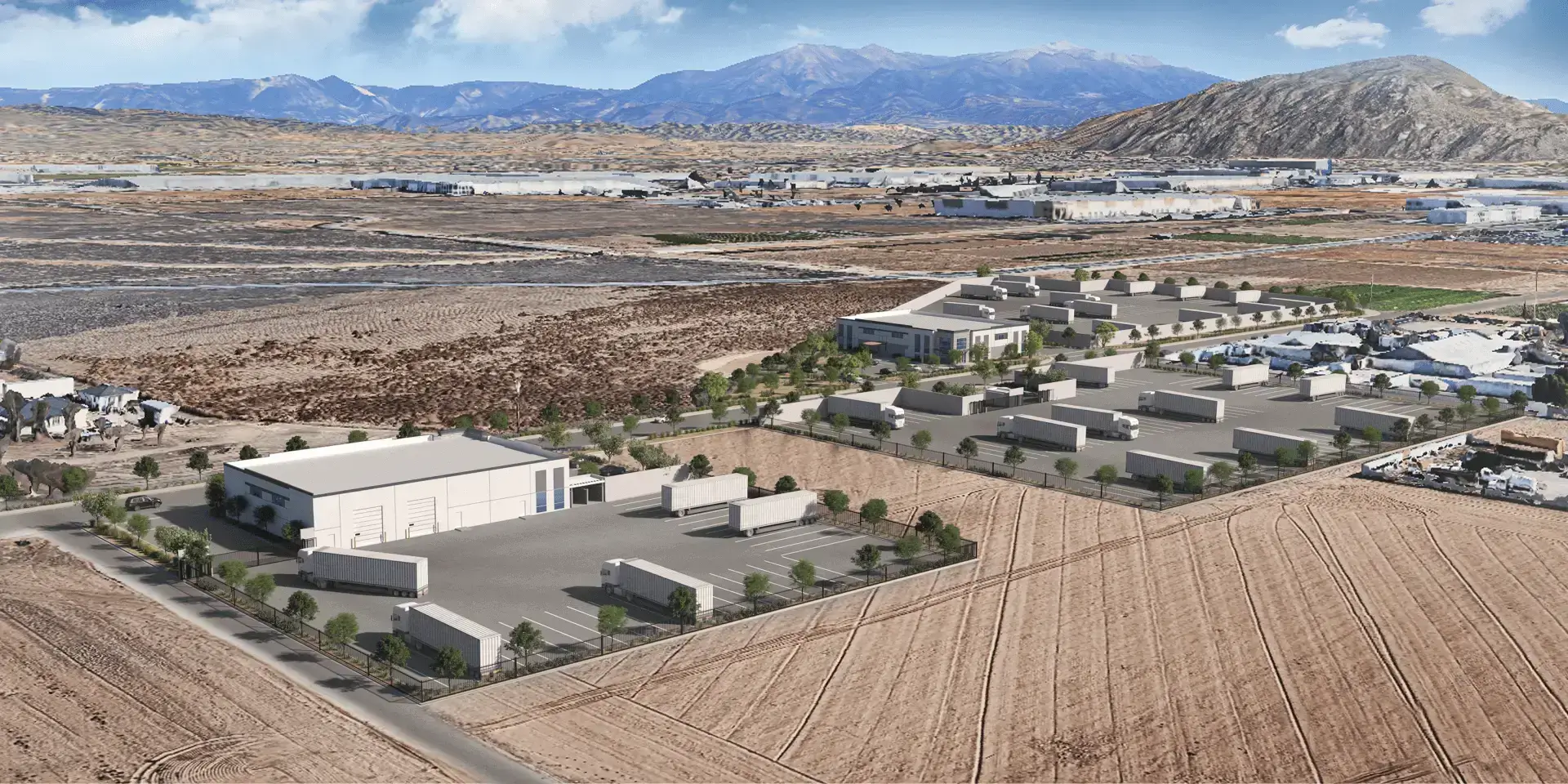 Aerial view of large warehouse and trucks.